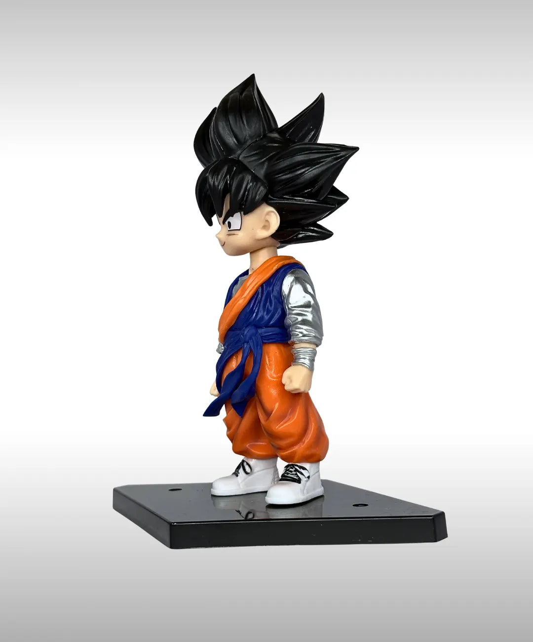 Figurine of a character in an orange and blue outfit with black spiky hair on a gray background