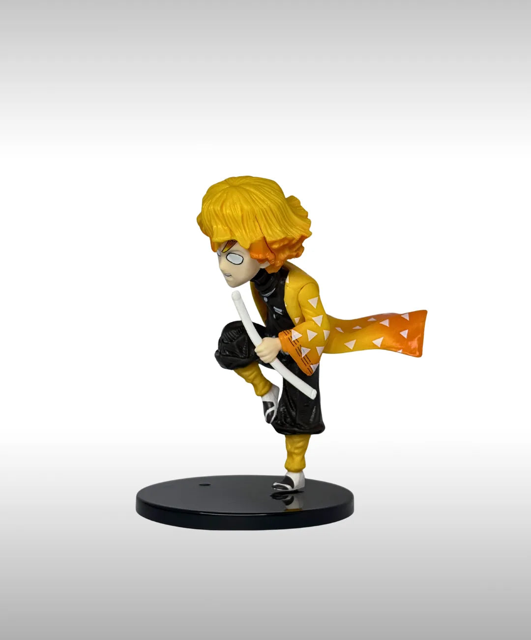 Figurine of a character with yellow hair and black outfit on a white background